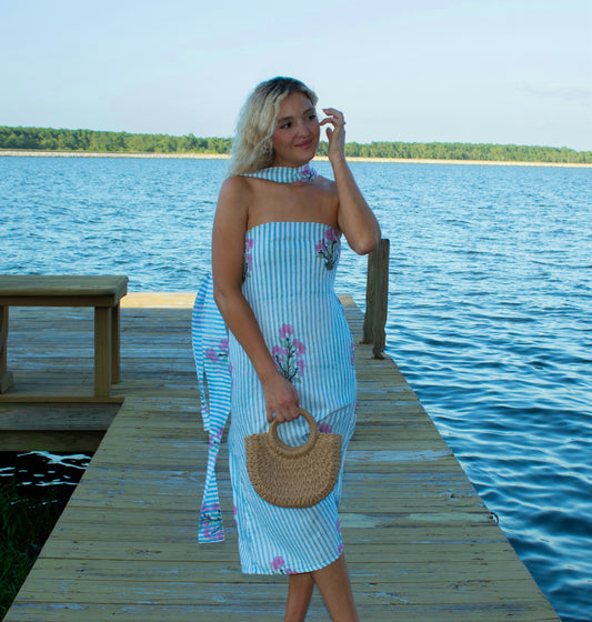 Woman in a striped dress standing on a dock by a lake