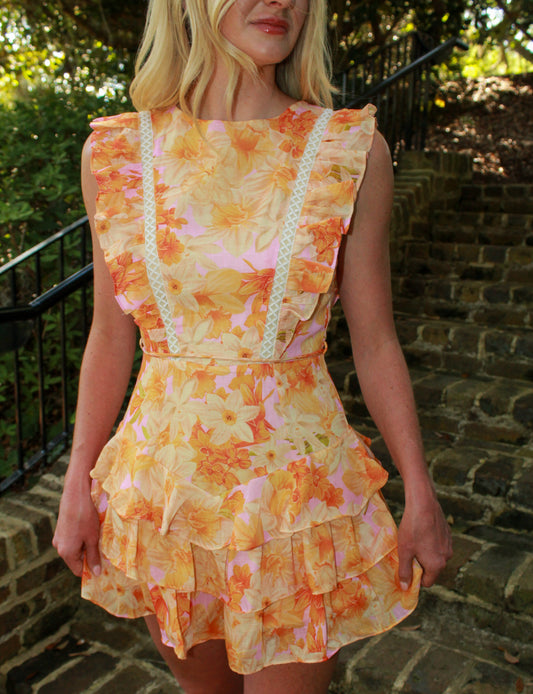 Floral ruffled dress in orange and pink, featuring lace trim and layered skirt, perfect for summer outings.