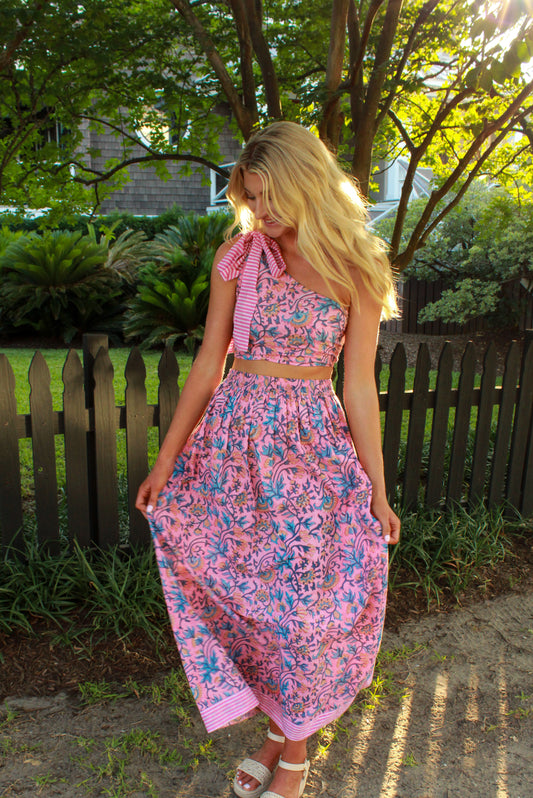 Floral pink two-piece maxi dress with a one-shoulder top and striped accent, perfect for summer outings.