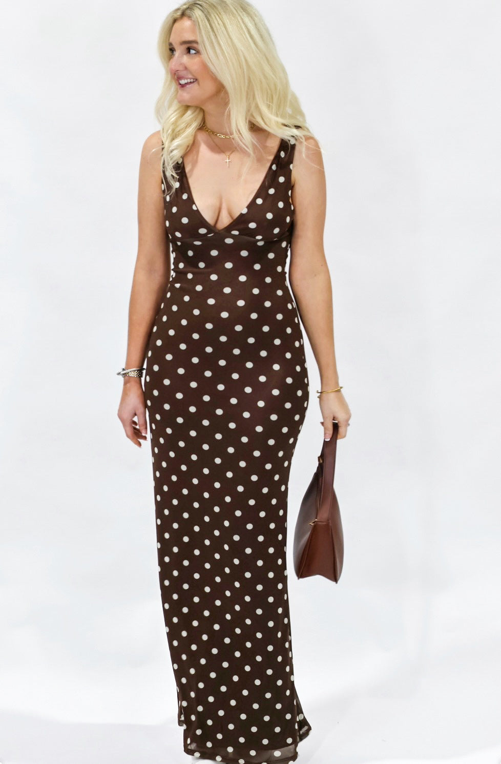 Woman wearing a brown polka dot dress against a white background