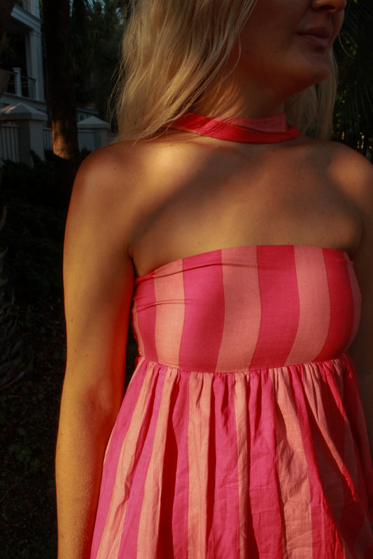 Pink striped strapless dress with flowing skirt, perfect for summer outings.