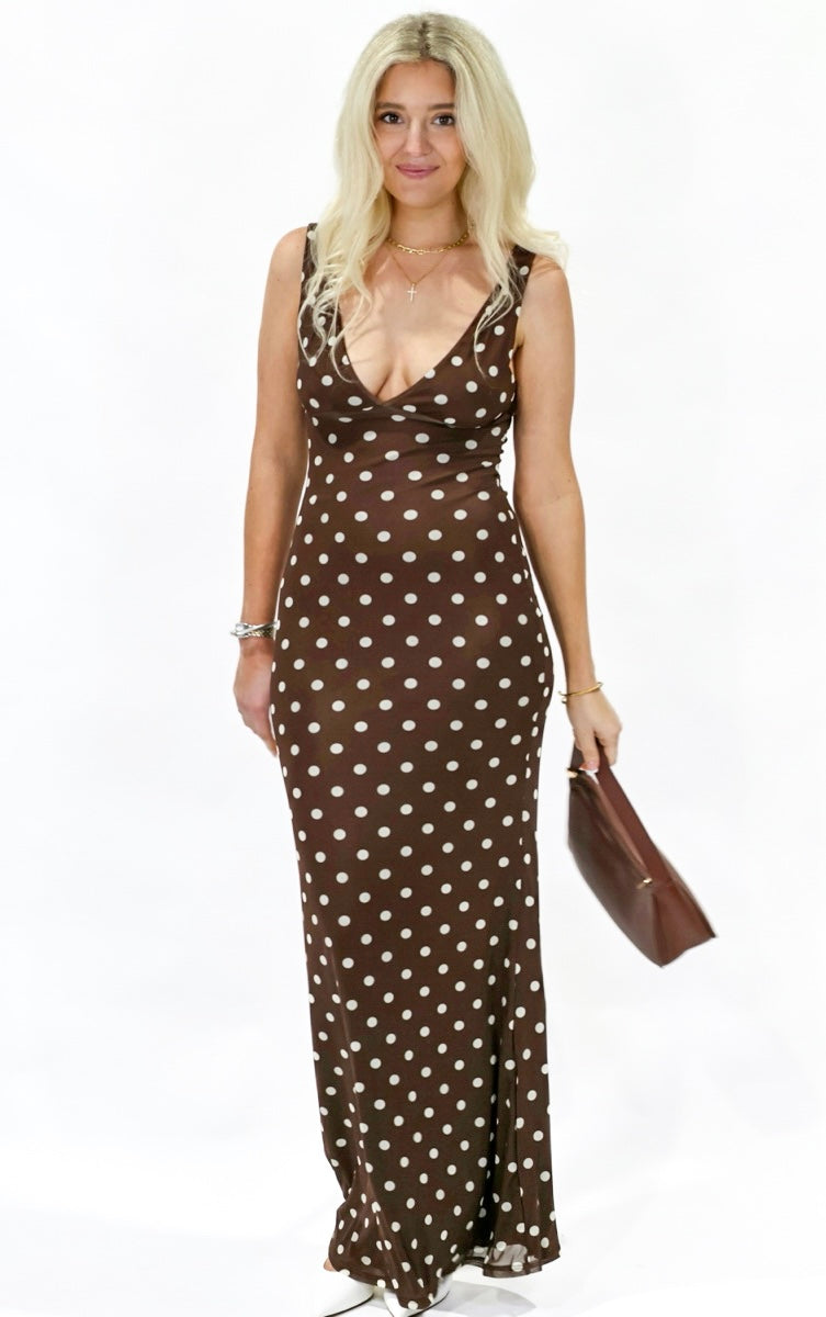 Woman wearing a brown polka dot dress on a white background