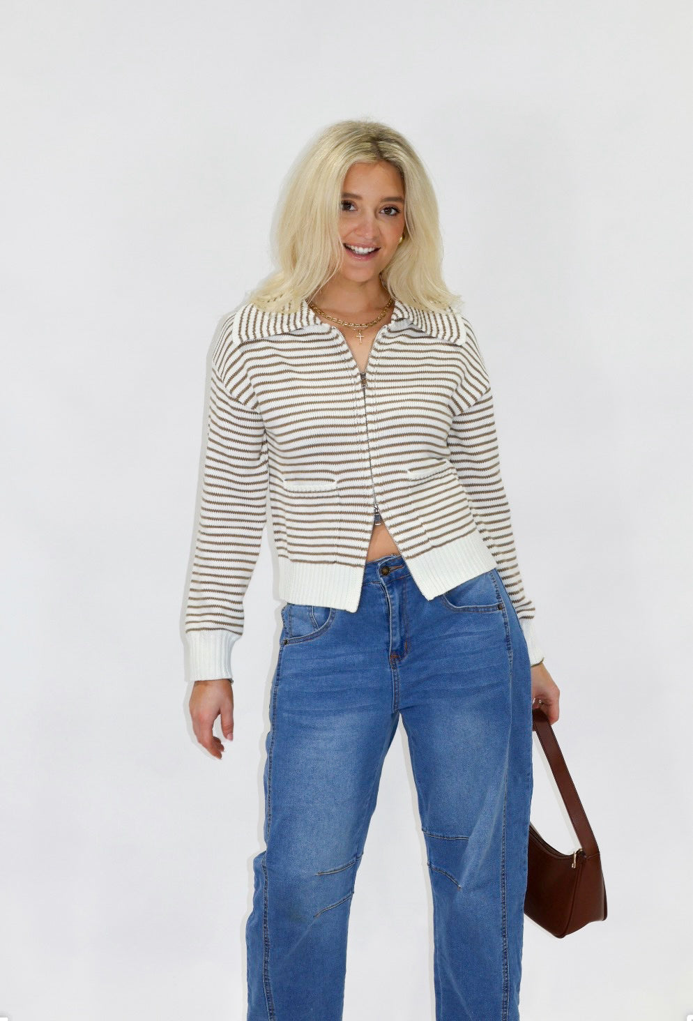 Woman wearing a striped shirt and blue jeans on a white background